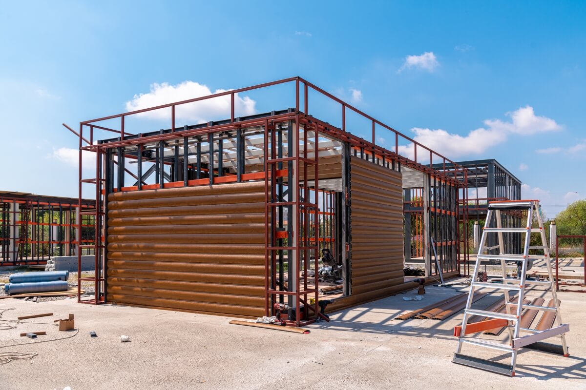 Auf der Baustelle kann ein Holzrahmenhaus besichtigt werden, das einen Vergleich zwischen Holzrahmenhäusern und traditionellen Strukturen ermöglicht.